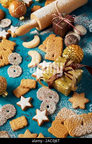 Noël cuisson fond avec les cookies de fête, des cadeaux et un rouleau à pâtisserie sur un arrière-plan hiver cool blue vue high angle Banque D'Images