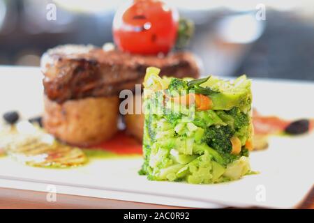 Préparé Chef Bonfile Steak sur pomme de terre rôti avec salade, garniture de légumes grillés et brocolli mash Banque D'Images