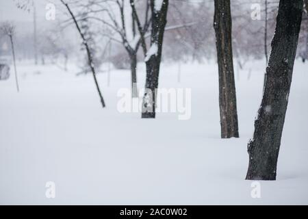 La silhouette d'un homme marchant le long d'une rue enneigée. Les fortes chutes de neige dans la ville. Image floue d'un homme. Arrière-plan de promo Web pour la publicité Banque D'Images