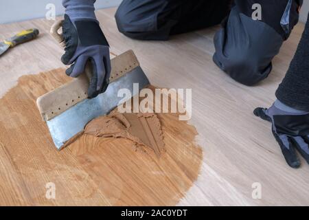 Master plancher à l'aide d'une spatule dans la main. Préparation du coulis de parquet. La retenue de mélange, de vernis et d'un petit mélange de bois. Vernissage-pré Banque D'Images