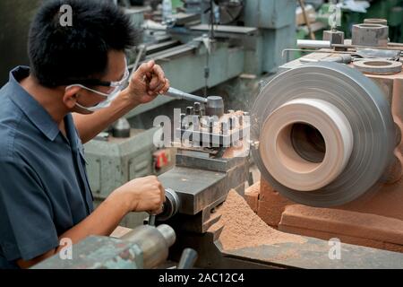 Les travailleurs professionnels font de l'usinage de pièces métalliques, machines de métal dans les grandes usines industrielles-image Banque D'Images