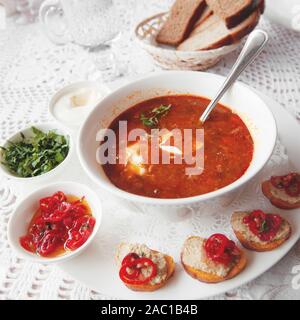 Soupe de tomate avec le poivre, le persil les épices dans une assiette blanche dans un restaurant avec un ensemble de canapés. Close up. Banque D'Images