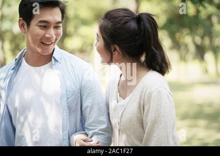 Young Asian couple walking parler dans le chat Banque D'Images