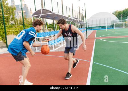 Confiant deux sportifs fit jouer au basket-ball sur un terrain de jeu Banque D'Images