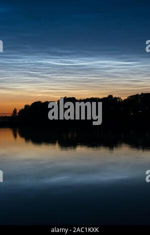 Nuages noctilucents (nuit) : bleu nuages lumineux de couleur argentée nuages dans la haute atmosphère sur un lac près de Gouda, Hollande. Banque D'Images
