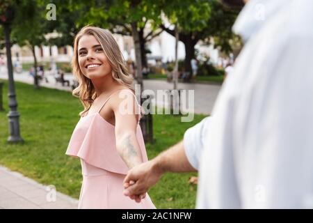 Photo d'un optimiste positive happy young couple aimant la marche en plein air de la rue Main dans la main de l'autre. Banque D'Images