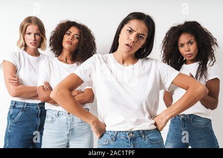 Image d'une des jeunes femmes agressif grave friends posing multiraciale isolated over white wall background. Banque D'Images