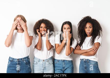 Image d'une jolie jeune femme friends posing multiraciale isolated over white wall background faisant des gestes avec les mains sur les oreilles, la bouche et les yeux. Banque D'Images