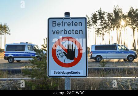 Brandenburg, Allemagne. 30 novembre, 2019. Un panneau avec l'inscription 'Personne ne peut entrer dans les locaux de l'entreprise" et les véhicules de police sont debout sur le bord de l'Jänschwalde brown coal mine à ciel ouvert appartenant à Lausitzer Energie Bergbau AG (LEAG). Le même jour, des militants environnementaux veulent protester contre la politique climatique à la centrale électrique de Jänschwalde et le ciel ouvert de Jänschwalde mine de lignite. Ende Gelände et le vendredi pour les futures ont annoncé un grand week-end d'action. Photo : Patrick Pleul/dpa-Zentralbild/dpa/Alamy Live News Crédit : afp photo alliance/Alamy Live News Banque D'Images