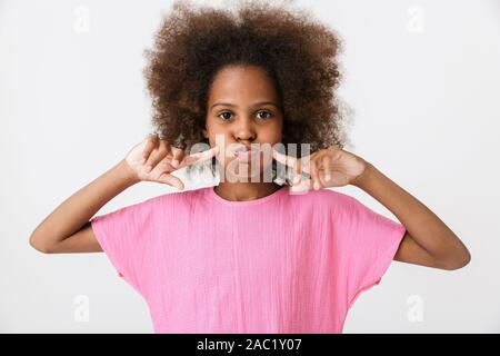 Happy funny little girl wearing pink blouse africains isolés sur fond blanc, grimaces Banque D'Images