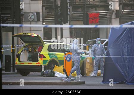 Le personnel judiciaire à ceinturée autour du pont de Londres dans le centre de Londres après un attentat terroriste portant une faux au soleil qui est allé sur un couteau rampage tuant deux personnes, a été abattu par la police. Banque D'Images