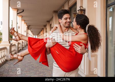 Image couple romantique dans les mains et tout en souriant autour de belle construction Banque D'Images