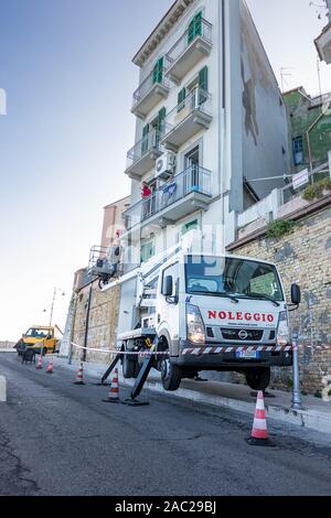 Ortona, Italie - 26 octobre 2019 : chariot avec panier pour travailler sur les bâtiments avec les travailleurs au travail à Ortona Banque D'Images