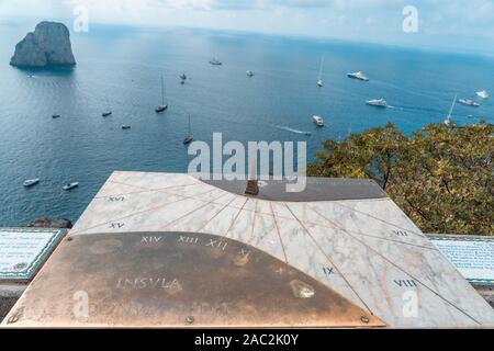 Capri, Italie - 13 août 2019 : cadran solaire en bronze sur marbre horlogue avec vue sur la mer Tyrrhénienne en faraglioni Banque D'Images