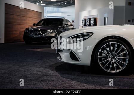 Deux voitures garées dans auto show avec roues sur le mur à l'arrière-plan Banque D'Images