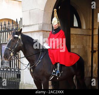 Household Cavalry dans leurs longs manteaux traditionnels uniforme rouge à Whitehall, Londres, UK Banque D'Images