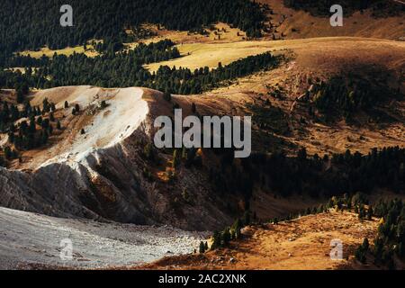 Dolomites hills. Vue depuis le sommet du mountain d'arbres partiellement éclairée par le soleil Banque D'Images