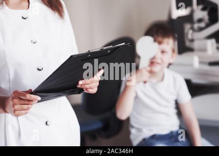 Femme avec des tests d'acuité visuelle les documents de petit garçon Banque D'Images