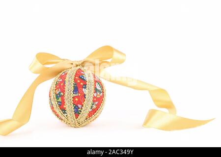 Découpage à la main isolé Boule de Noël avec des flocons en satin doré ruban sur fond blanc Banque D'Images