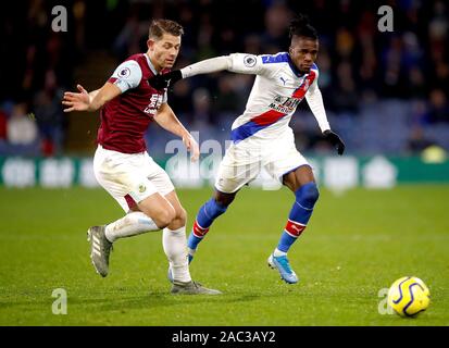 Le Crystal Palace Wilfried Zaha (droite) et du Burnley James Tarkowski (à gauche) bataille pour la balle au cours de la Premier League match à Turf Moor, Burnley. Banque D'Images