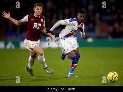 Le Crystal Palace Wilfried Zaha (droite) et du Burnley James Tarkowski (à gauche) bataille pour la balle au cours de la Premier League match à Turf Moor, Burnley. Banque D'Images