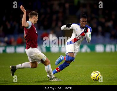 Le Crystal Palace Wilfried Zaha (droite) et du Burnley James Tarkowski (à gauche) bataille pour la balle au cours de la Premier League match à Turf Moor, Burnley. Banque D'Images