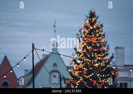 La décoration de l'ampoule et l'arbre de Noël contre ciel sombre. Tallinn, Estonie. Banque D'Images
