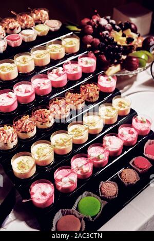 Divers desserts en verres sur table de restaurant - crème brûlée et le panna cotta, tonique libre Banque D'Images