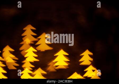 Lumières de Noël rend jaune Forme Pin Bokeh. Fond sombre concept with copy space Banque D'Images