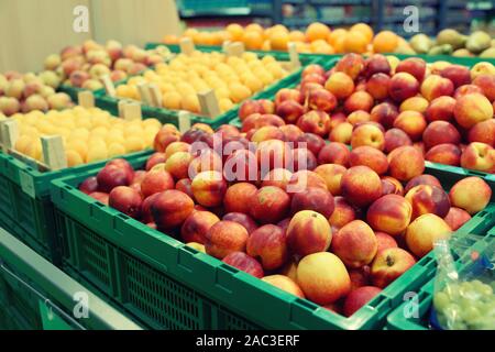 Les pêches et abricots en caisses en plastique, magasin d'alimentation, supermarché image tonique Banque D'Images