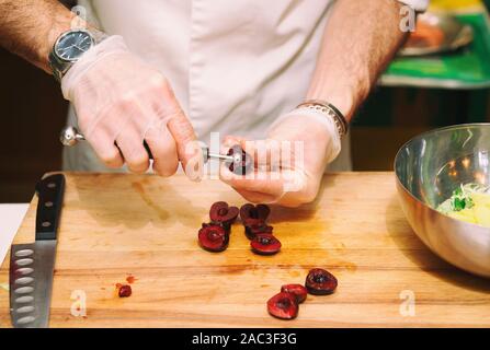 Chef, c'est retirer les pierres de cerise dans cuisine professionnelle, tonique libre Banque D'Images