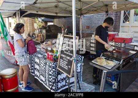 Le marché des roches Sydney Australie - une femme d'acheter des aliments de rue au marché un stand au marché du week-end dans la région de Sydney, Australie Banque D'Images