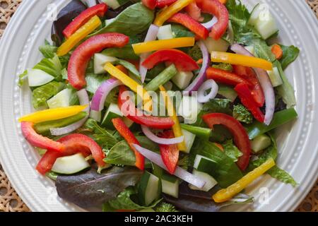 Extreme close up d'un sain salade crue sur un plateau débordant de la nutrition et des légumes colorés, y compris Mélange Printanier (mesclun), épinards, concombres, t Banque D'Images