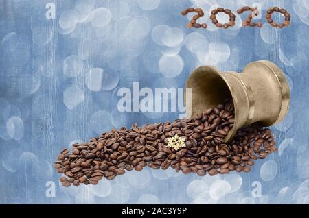 Carte de vœux de nouvel an avec café en grains éparpillés sur un fond bicolore en bois. 2020 date à partir de grains de café. Banque D'Images