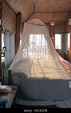Une moustiquaire couvrant un lit à l'intérieur d'une cabane dans le lac Inle au Myanmar Banque D'Images