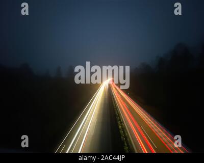 Bandes claires de voitures en mouvement sur une autoroute allemande de nuit Banque D'Images