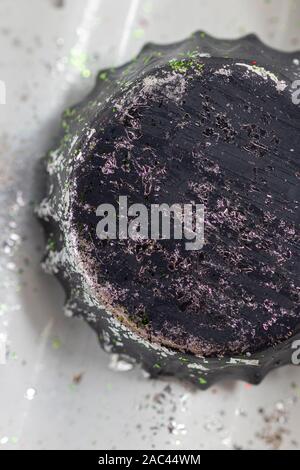 Bouchon de vase ancien peint en noir et peeling avec touches de vert. Close up. Banque D'Images