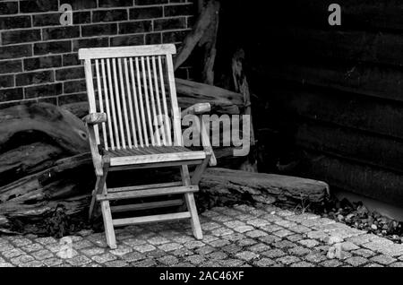 Chaise en bois vide, l'arrière-plan à partir de vieux morceaux de bois, planches de paroi latérale. Photo en noir et blanc, style rétro. Banque D'Images