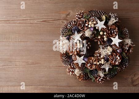 Couronne de Noël décoré avec des cônes de pin et de sapin sur la porte en bois Banque D'Images