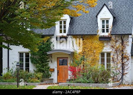 Vieille maison avec des briques peintes en blanc et lucarne avec couleurs d'automne Banque D'Images