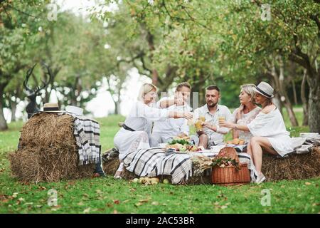 Photo de personnes ayant une bonne fois et reste sur le terrain avec table et sièges de paille Banque D'Images