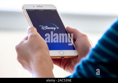 Calgary (Alberta). 28 Nov 2019 Canada : femme est titulaire d'un iphone plus avec le nouveau Disney + app sur ses mains. Disney + presse une nouvelle mise à jour de son vid en ligne Banque D'Images