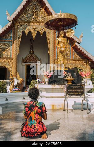 Thaï non identifié femme qui prie en face de Wat Phra Singh temple à Chiang Mai, Thaïlande. Banque D'Images