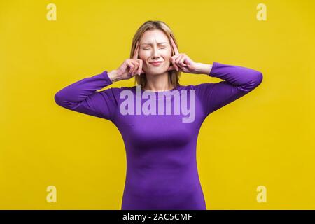 Maux de tête intenses. Portrait de femme malade bouleversé dans d'élégantes robe mauve serré debout lui touchant les temples et les grimaces de douleur, la souffrance la migraine Banque D'Images