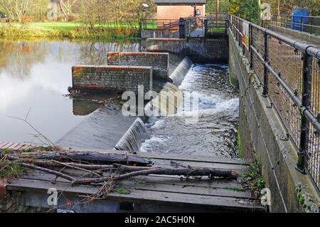 Un barrage et l'eau à la station de jaugeage sur la rivière Bure par les vestiges de l'ancien moulin à eau à Horstead, Norfolk, Angleterre, Royaume-Uni, Europe. Banque D'Images