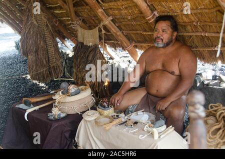 Un homme hawaïenne sensibilise les visiteurs à propos de plusieurs anciennes objets hawaïens à Pu'uhonua o Honaunau (Ville de Refuge), Kona, Big Island du Sud Banque D'Images