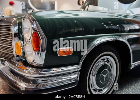 STUTTGART, ALLEMAGNE - 16 octobre 2018 : Musée Mercedes. Personne dans la Red Hat à l'arrière-plan. Photo de l'avant de la superbe voiture de couleur vert brillant Banque D'Images