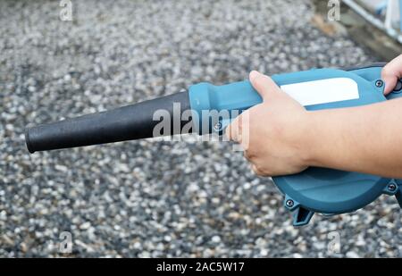 Hand Holding Blue Air Blower, utiliser pour enlever la poussière de la machine électrique et de feuilles dans un jardin. Banque D'Images