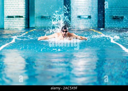 Nageur professionnel faire de l'exercice dans la piscine intérieure. Banque D'Images