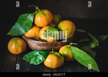 Mandarine avec des feuilles sur un pays à l'ancienne table. Focus sélectif. L'horizontale. Banque D'Images